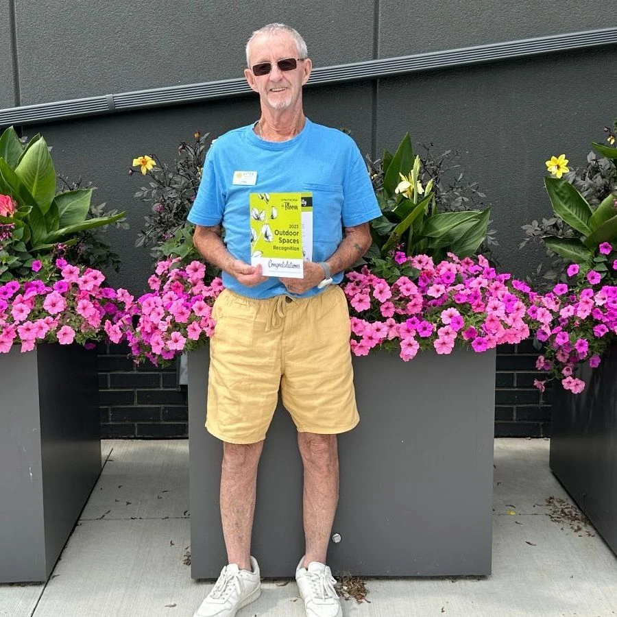 Senior standing in front of flower planters