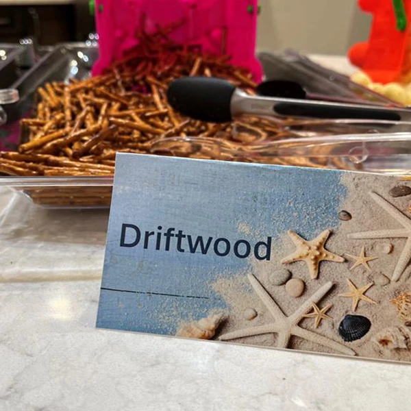 A postcard next to some stick pretzels. The postcard says, 