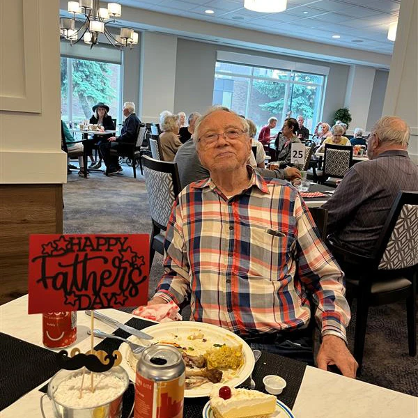 Man sitting next to a sign that says,
